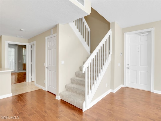15329 Laughing Gull Ln, Bonita Springs, FL 34135 - staircase featuring wood finished floors and baseboards