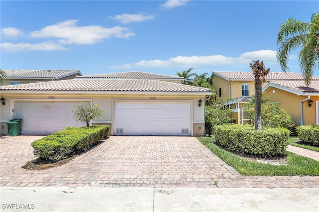15329 Laughing Gull Ln, Bonita Springs, FL 34135 - view of front facade with stucco siding, driveway, a tile roof, and an attached garage