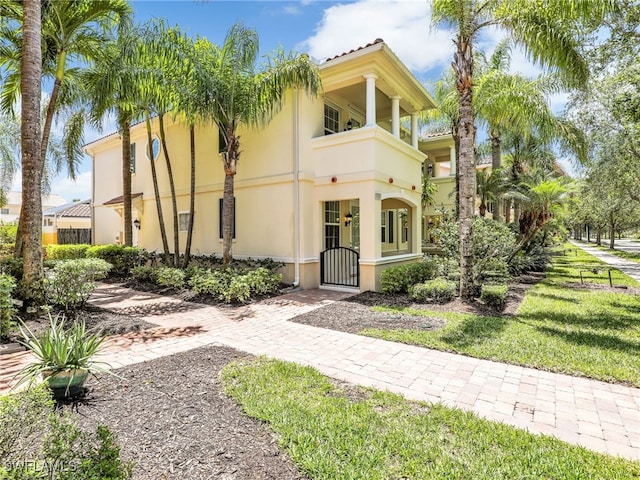 15329 Laughing Gull Ln, Bonita Springs, FL 34135 - mediterranean / spanish-style house featuring stucco siding, a gate, and a balcony