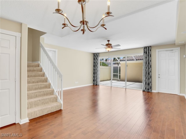 15329 Laughing Gull Ln, Bonita Springs, FL 34135 - unfurnished living room featuring a ceiling fan, stairs, wood finished floors, and a chandelier
