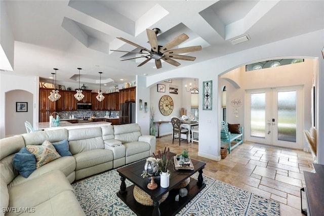 208 SW 15th St, Cape Coral, FL 33991 - living area with arched walkways, coffered ceiling, french doors, recessed lighting, and stone tile flooring