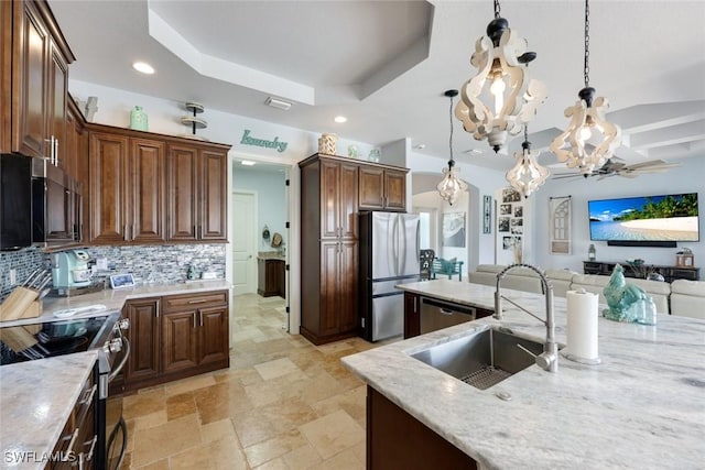 208 SW 15th St, Cape Coral, FL 33991 - kitchen featuring appliances with stainless steel finishes, a sink, open floor plan, tasteful backsplash, and a raised ceiling