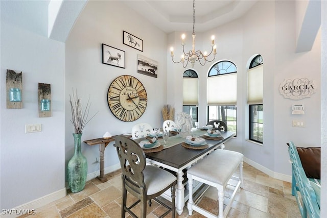 208 SW 15th St, Cape Coral, FL 33991 - dining space with stone tile floors, a chandelier, baseboards, and a high ceiling