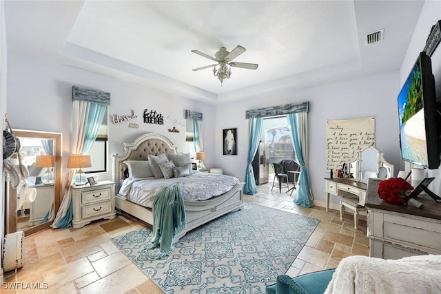 208 SW 15th St, Cape Coral, FL 33991 - bedroom with a tray ceiling, access to exterior, stone tile floors, and a ceiling fan