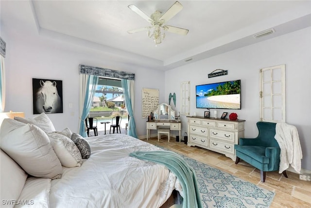 208 SW 15th St, Cape Coral, FL 33991 - bedroom with a tray ceiling, stone tile flooring, a ceiling fan, baseboards, and access to outside