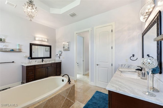 208 SW 15th St, Cape Coral, FL 33991 - bathroom featuring two vanities, a garden tub, and a chandelier