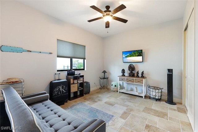 208 SW 15th St, Cape Coral, FL 33991 - living area with ceiling fan, stone tile floors, and baseboards