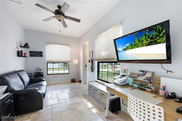 208 SW 15th St, Cape Coral, FL 33991 - living room with stone tile floors, plenty of natural light, a ceiling fan, and baseboards