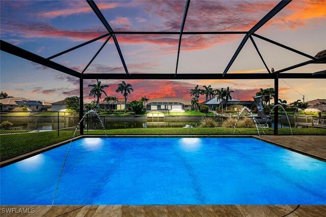 208 SW 15th St, Cape Coral, FL 33991 - pool at dusk featuring glass enclosure, a water view, and a patio area