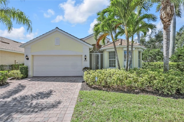 8460 Benelli Ct, Naples, FL 34114 - view of front facade with stucco siding, decorative driveway, and a garage