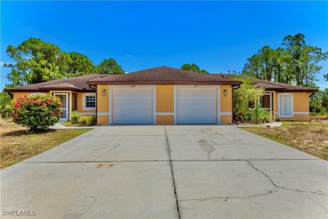 869/871 Eisenhower Blvd, Lehigh Acres, FL 33974 - ranch-style house featuring stucco siding, a garage, and concrete driveway