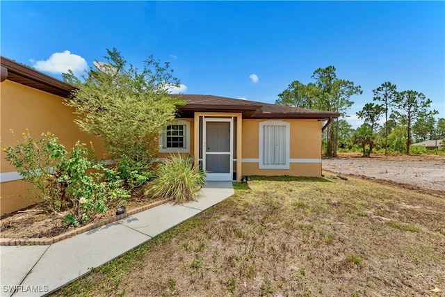 869/871 Eisenhower Blvd, Lehigh Acres, FL 33974 - view of front of property featuring stucco siding and a front lawn