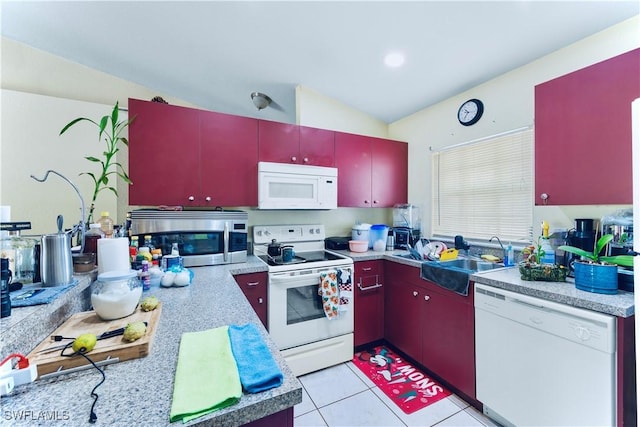 869/871 Eisenhower Blvd, Lehigh Acres, FL 33974 - kitchen featuring white appliances, red cabinetry, a sink, and light countertops