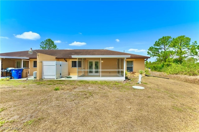 869/871 Eisenhower Blvd, Lehigh Acres, FL 33974 - rear view of house featuring french doors, stucco siding, and a yard