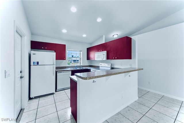 869/871 Eisenhower Blvd, Lehigh Acres, FL 33974 - kitchen featuring white appliances, a peninsula, light tile patterned floors, vaulted ceiling, and dark countertops
