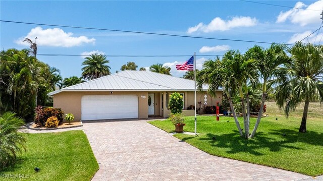 2912 SW 1st Ter, Cape Coral, FL 33991 - ranch-style house featuring stucco siding, a garage, a front lawn, and decorative driveway