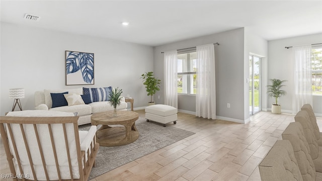 living area featuring light wood finished floors, baseboards, and recessed lighting