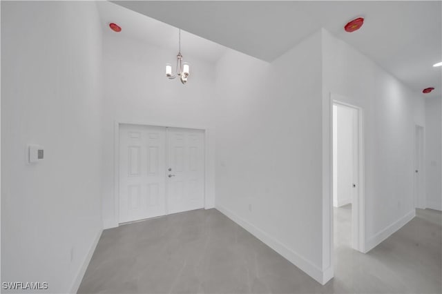 1904 E 11th St, Lehigh Acres, FL 33936 - foyer entrance featuring baseboards, a chandelier, and concrete flooring