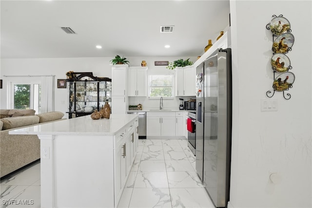 4174 58th Ave NE, Naples, FL 34120 - kitchen featuring stainless steel appliances, light marble finish floors, open floor plan, a sink, and light countertops