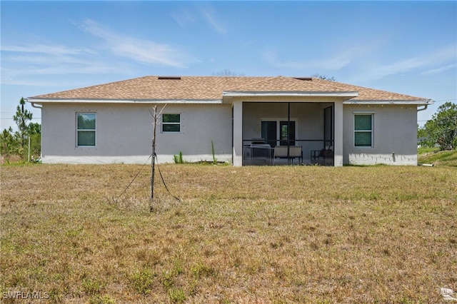 4174 58th Ave NE, Naples, FL 34120 - back of property featuring stucco siding, a lawn, roof with shingles, and a sunroom