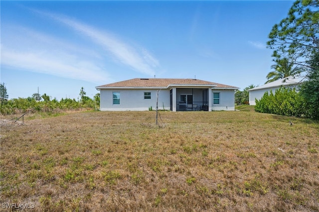 4174 58th Ave NE, Naples, FL 34120 - back of property with a lawn, stucco siding, and a sunroom