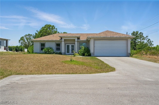 4174 58th Ave NE, Naples, FL 34120 - view of front of home featuring french doors, stucco siding, driveway, a garage, and a front lawn