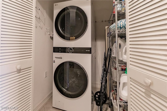 1878 Tarpon Bay Dr S Unit 102, Naples, FL 34119 - clothes washing area featuring estacked washer and dryer, tile patterned flooring, and baseboards