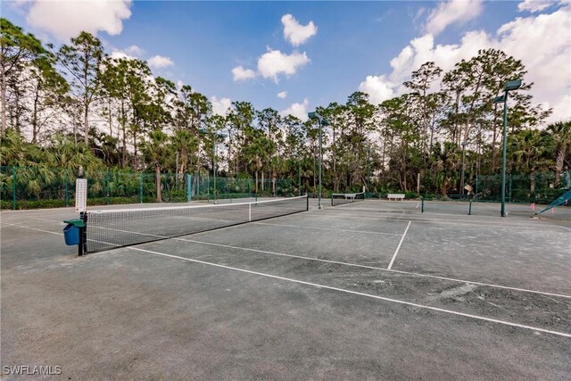 1878 Tarpon Bay Dr S Unit 102, Naples, FL 34119 - view of tennis court featuring fence and view of scattered trees