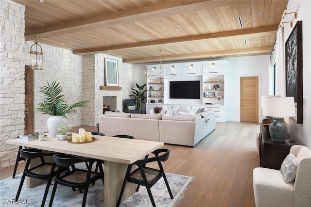 186 N St, Naples, FL 34108 - dining area with a fireplace, wooden ceiling with exposed beams, and light wood-style flooring