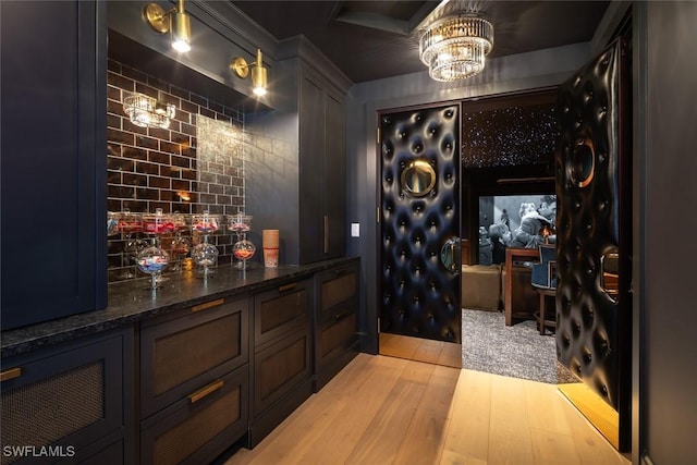 186 N St, Naples, FL 34108 - wine area featuring a chandelier, light wood-style floors, and a bar