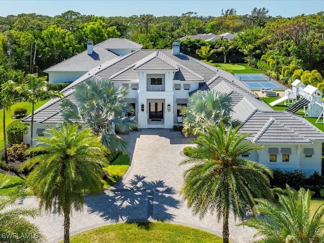 186 N St, Naples, FL 34108 - view of front of home featuring a tiled roof, a chimney, and stucco siding