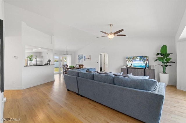 2210 SW 14th Ave, Cape Coral, FL 33991 - living area with vaulted ceiling, ceiling fan, light wood-type flooring, arched walkways, and baseboards