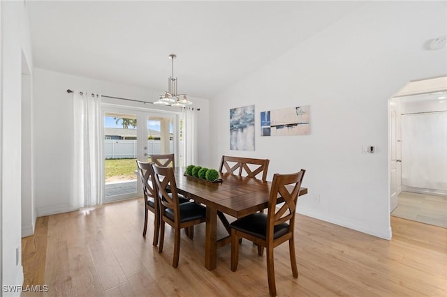 2210 SW 14th Ave, Cape Coral, FL 33991 - dining space with light wood-style flooring, lofted ceiling, arched walkways, and a chandelier
