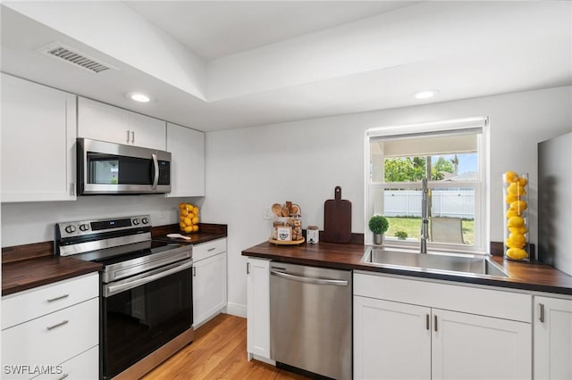 2210 SW 14th Ave, Cape Coral, FL 33991 - kitchen featuring stainless steel appliances, wood counters, a sink, recessed lighting, and white cabinets
