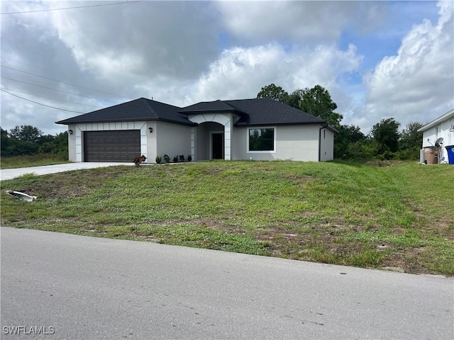 view of front of property with stucco siding, an attached garage, concrete driveway, and a front lawn