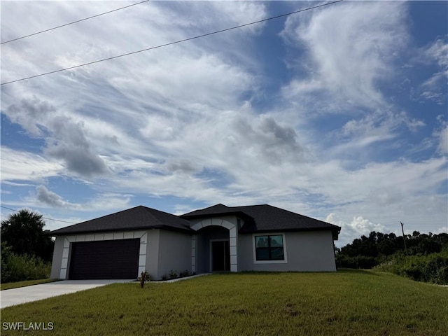 view of front of house with driveway, stucco siding, a garage, and a front yard
