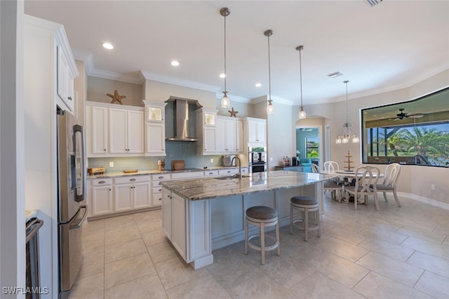 1456 Mockingbird Dr, Naples, FL 34120 - kitchen with wall chimney exhaust hood, a sink, stainless steel appliances, backsplash, and stone counters