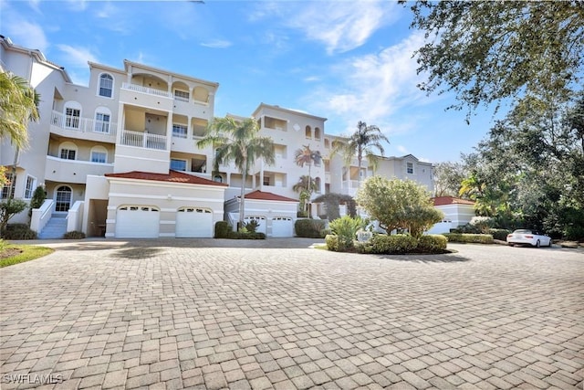 view of property with a garage, a residential view, and driveway