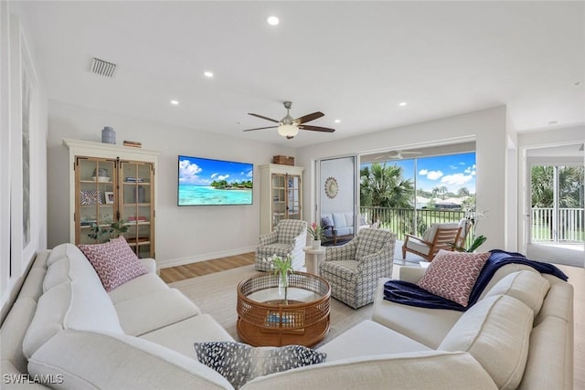 living area featuring plenty of natural light, light wood-style flooring, a ceiling fan, recessed lighting, and baseboards