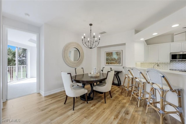 dining room featuring light wood-type flooring, a chandelier, baseboards, and recessed lighting