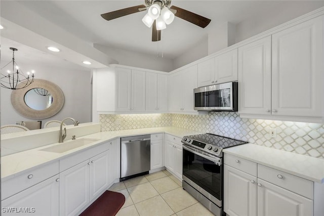 kitchen featuring stainless steel appliances, a sink, white cabinets, and recessed lighting