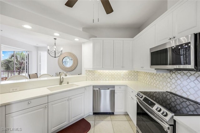 kitchen featuring appliances with stainless steel finishes, a sink, light tile patterned floors, recessed lighting, and white cabinetry