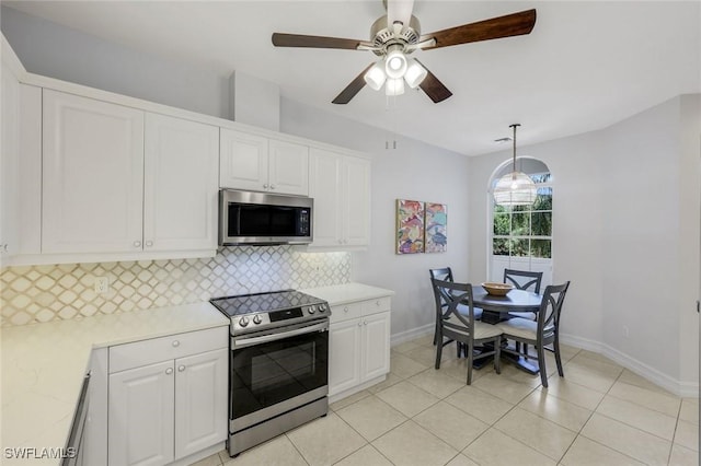 kitchen featuring appliances with stainless steel finishes, baseboards, backsplash, light countertops, and white cabinets