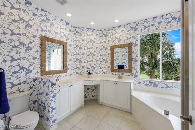 bathroom with wallpapered walls, double vanity, a bath, tile patterned floors, and toilet