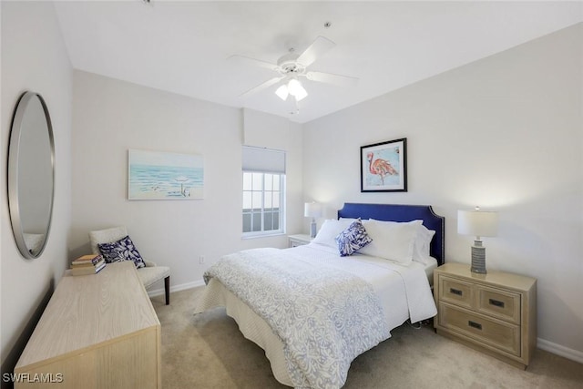 bedroom featuring light colored carpet, baseboards, and ceiling fan