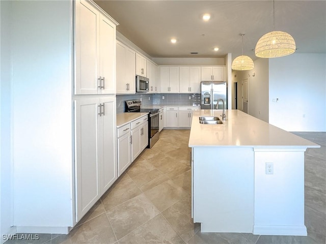 5583 Double Eagle Cir Unit 4141, Ave Maria, FL 34142 - kitchen featuring appliances with stainless steel finishes, a sink, a center island with sink, backsplash, and white cabinetry