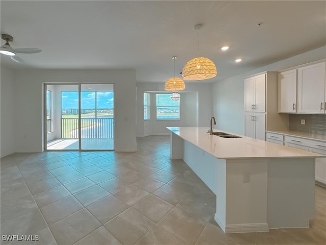 5583 Double Eagle Cir Unit 4141, Ave Maria, FL 34142 - kitchen with a sink, baseboards, light countertops, an island with sink, and recessed lighting
