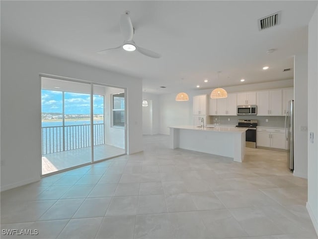 5583 Double Eagle Cir Unit 4141, Ave Maria, FL 34142 - kitchen featuring stainless steel appliances, a sink, light countertops, white cabinets, and a center island with sink