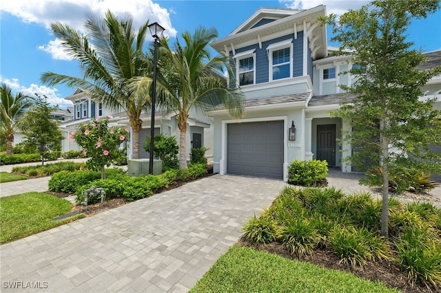 2647 Seychelles Cir Unit 2203, Naples, FL 34112 - view of front facade with decorative driveway, stucco siding, a garage, and cooling unit