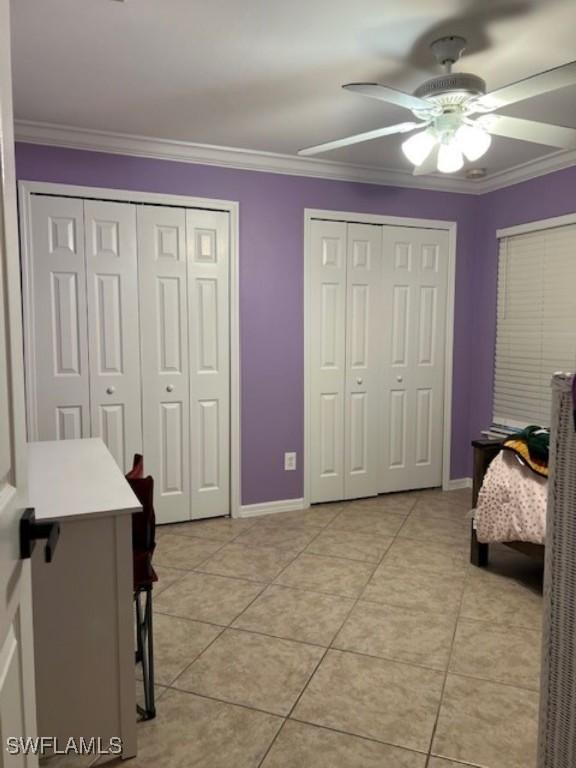 1155 Bush St E, Immokalee, FL 34142 - bedroom with two closets, light tile patterned floors, crown molding, baseboards, and ceiling fan